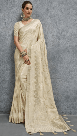 Elegant cream Banarasi silk saree with woven jacquard floral motifs and rich border, paired with matching blouse, perfect for wedding, festive and party wear.
