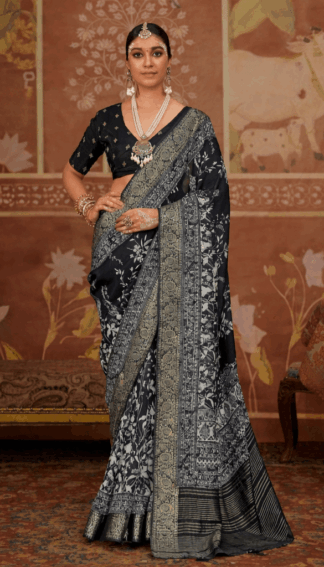 Woman wearing elegant black light weighted dola silk saree with intricate silver zari floral and traditional woven border, paired with matching blouse and statement silver jewelry in a heritage-themed setting.