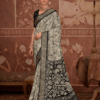 model wearing a black and ivory saree with intricate floral and peacock motifs, paired with a black blouse