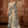 Model wearing an off-white floral printed silk saree with gold zari border, paired with matching blouse