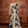Model wearing an ivory silk saree with bold black floral prints and gold zari border.
