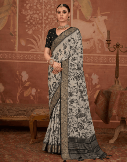 Model wearing a black and grey floral printed silk saree with intricate zari border, paired with a black blouse