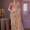 Elegant beige silk saree with pink blouse and floral print, featuring rich zari border and traditional bridal jewellery styling