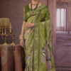 Model wearing a green floral printed silk saree with gold zari border.