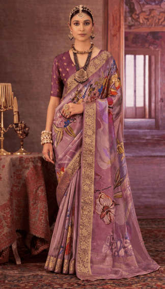 Woman wearing a lavender chinon silk saree with multicolor floral print and gold woven border styled with traditional necklace and earrings.
