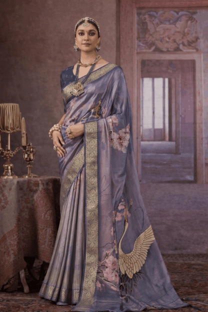 Steel grey silk saree with gold zari border, floral prints, and crane motif on the pallu.