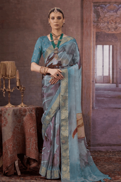 Sky blue silk saree with gold zari woven border and artistic abstract prints on the drape and pallu.